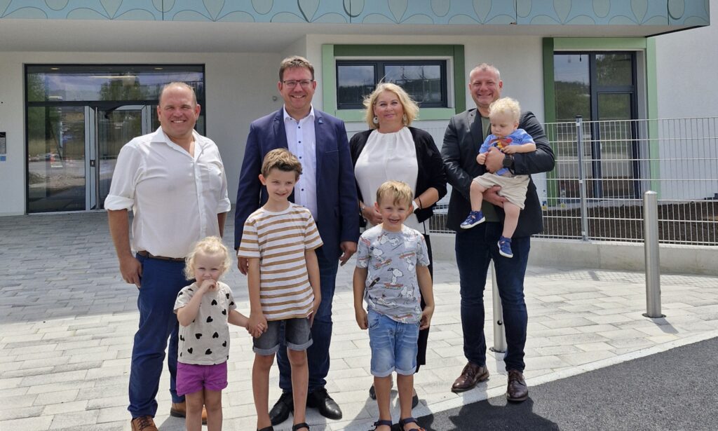 Abteilungsleiter Ing. Richard Biber, Bürgermeister Christian Haberhauer, Bildungsstadträtin Doris Koch, MSc. und Vizebürger¬meister Dominic Hörlezeder mit Lotta, Emil, Anton und Matteo vor dem neuen Kindergarten.