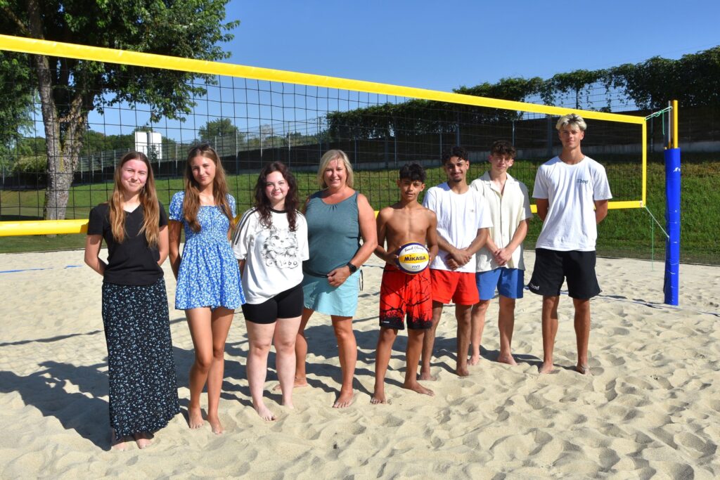 Ruth, Emily, Nora, GRin Claudia Weinbrenner, Ahmad, Mustafa, Elias und VCA Trainer Robert Gavam am Beachvolleyballplatz im Uferpark